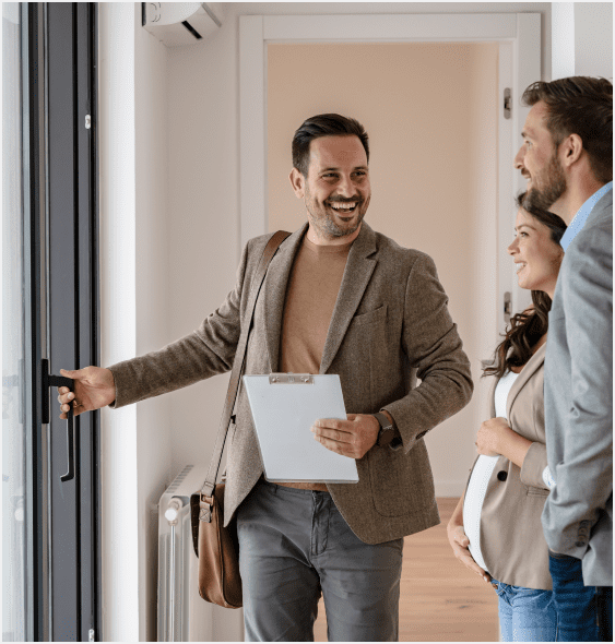A man holding a laptop and pointing to something